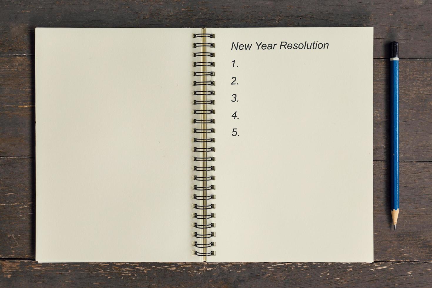 Business concept - Top view notebook writing New Year Resolution. photo