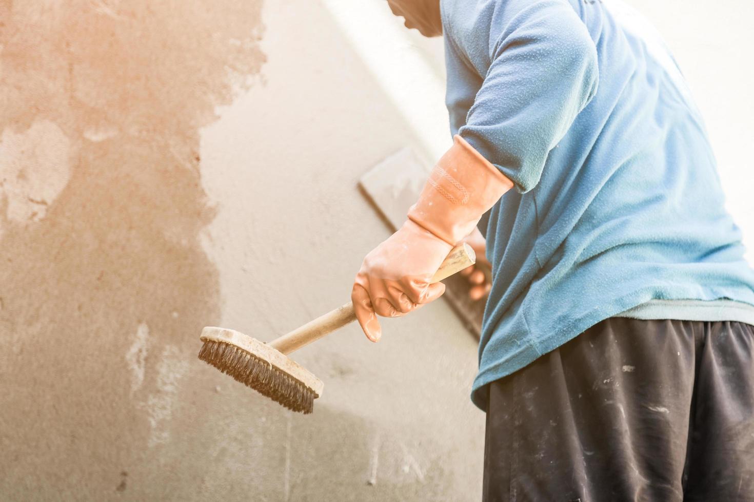 plasterer concrete worker at wall of house construction photo