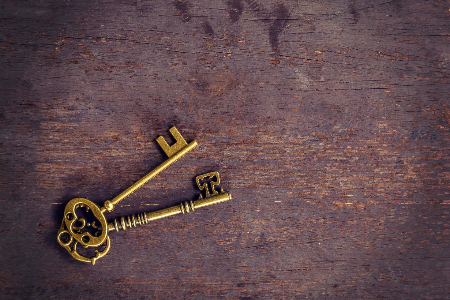 Old gold key vintage on wood background with space. photo