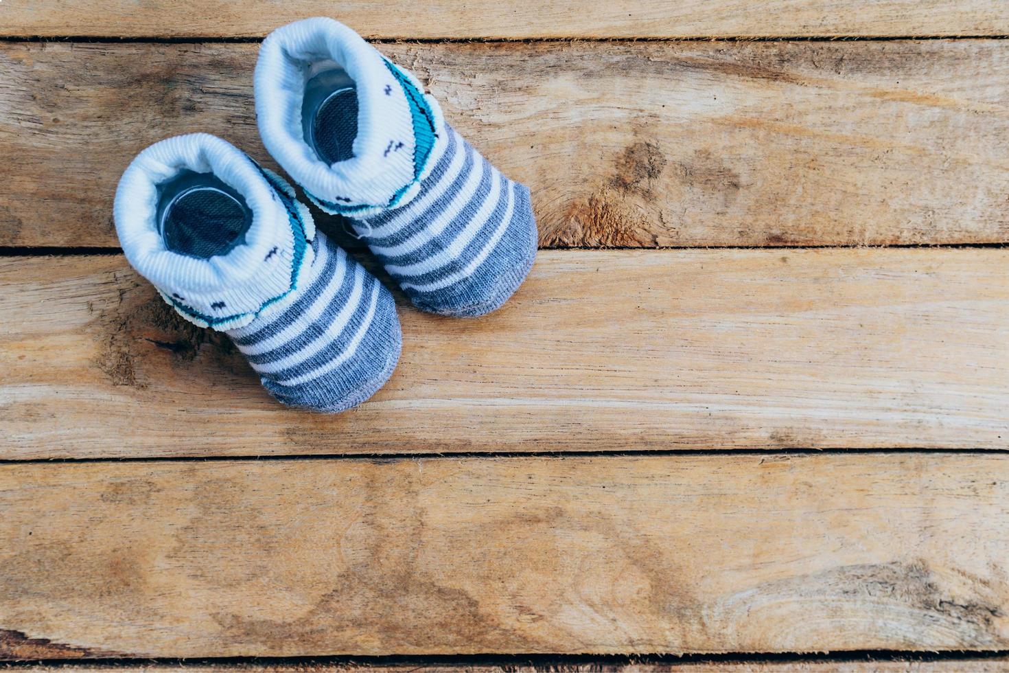Baby shoes on wooden background with space photo