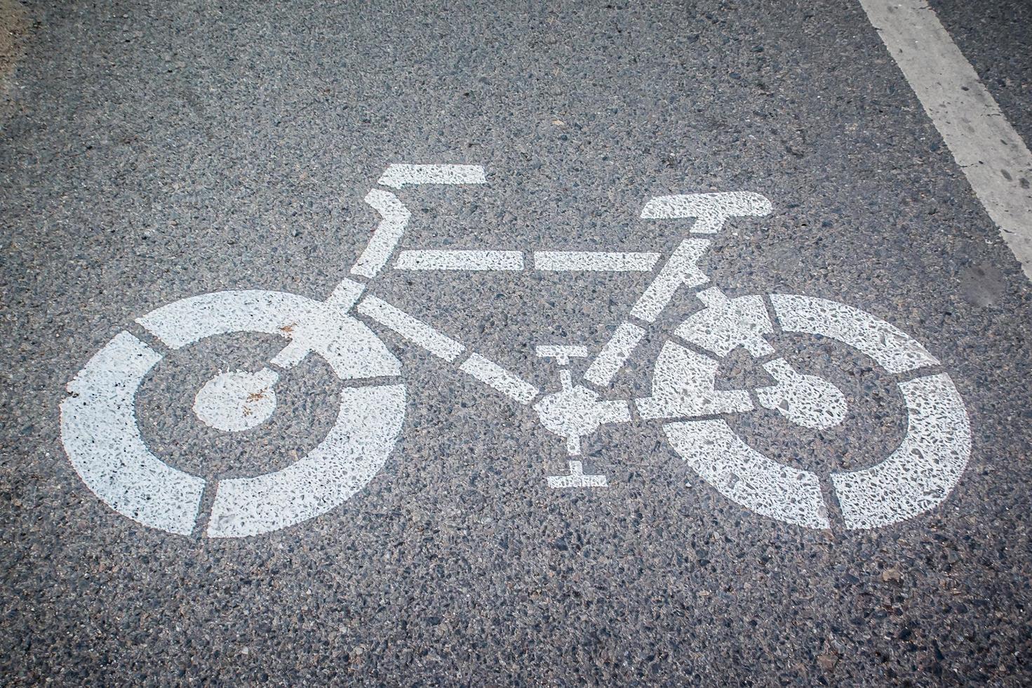 blanco flecha y bicicleta firmar camino en el la carretera. foto