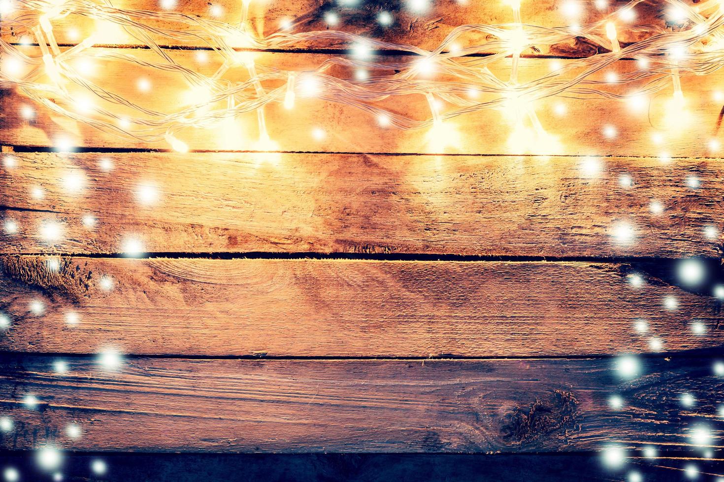 christmas light and snow on wooden background with space photo