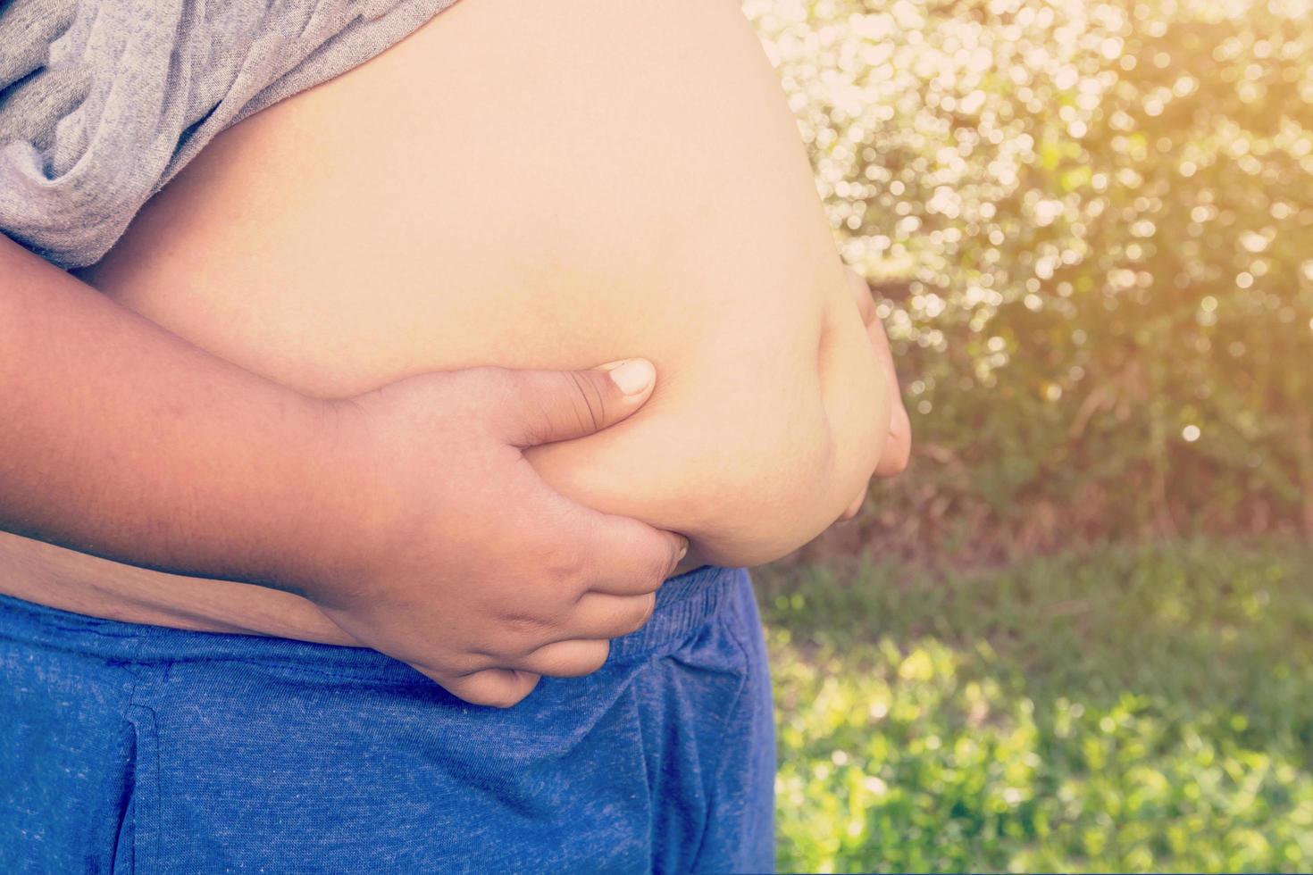 Boy fat and unhealthy with natural light vintage background. photo