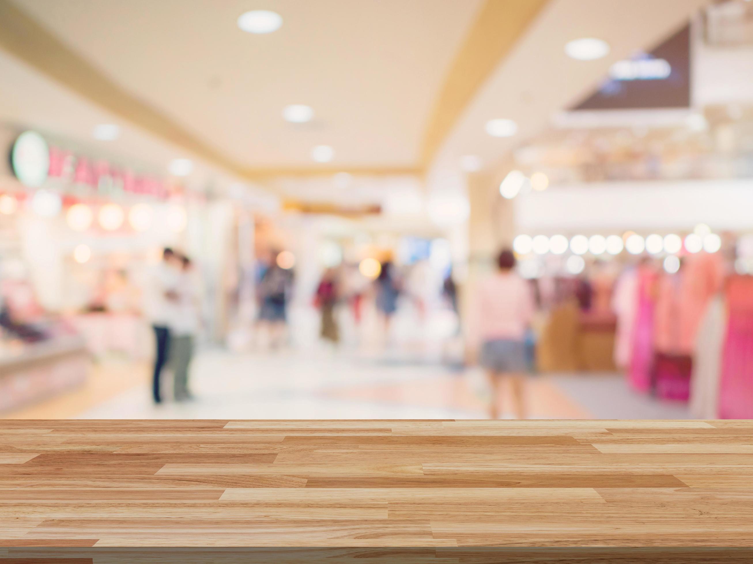 Wood table and shopping mall Blurred background with space for product