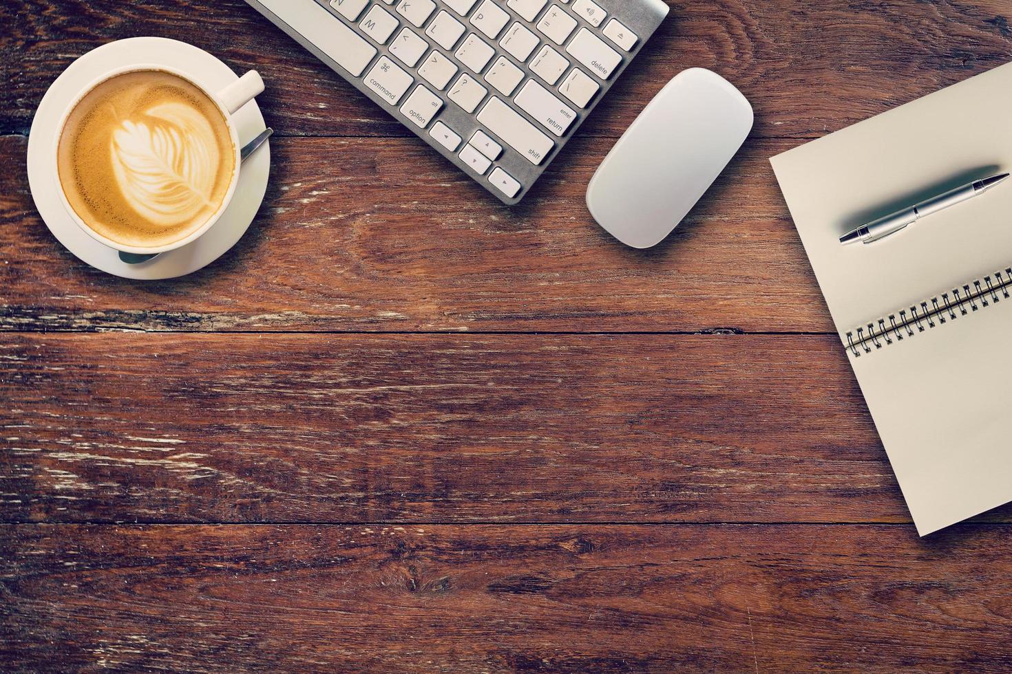 Office table with computer, notebook and coffee cup. View from above for vintage tone. photo