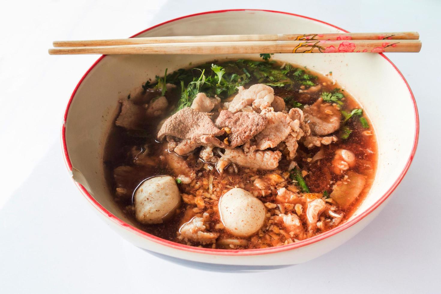 thai noodles and pork on white table photo