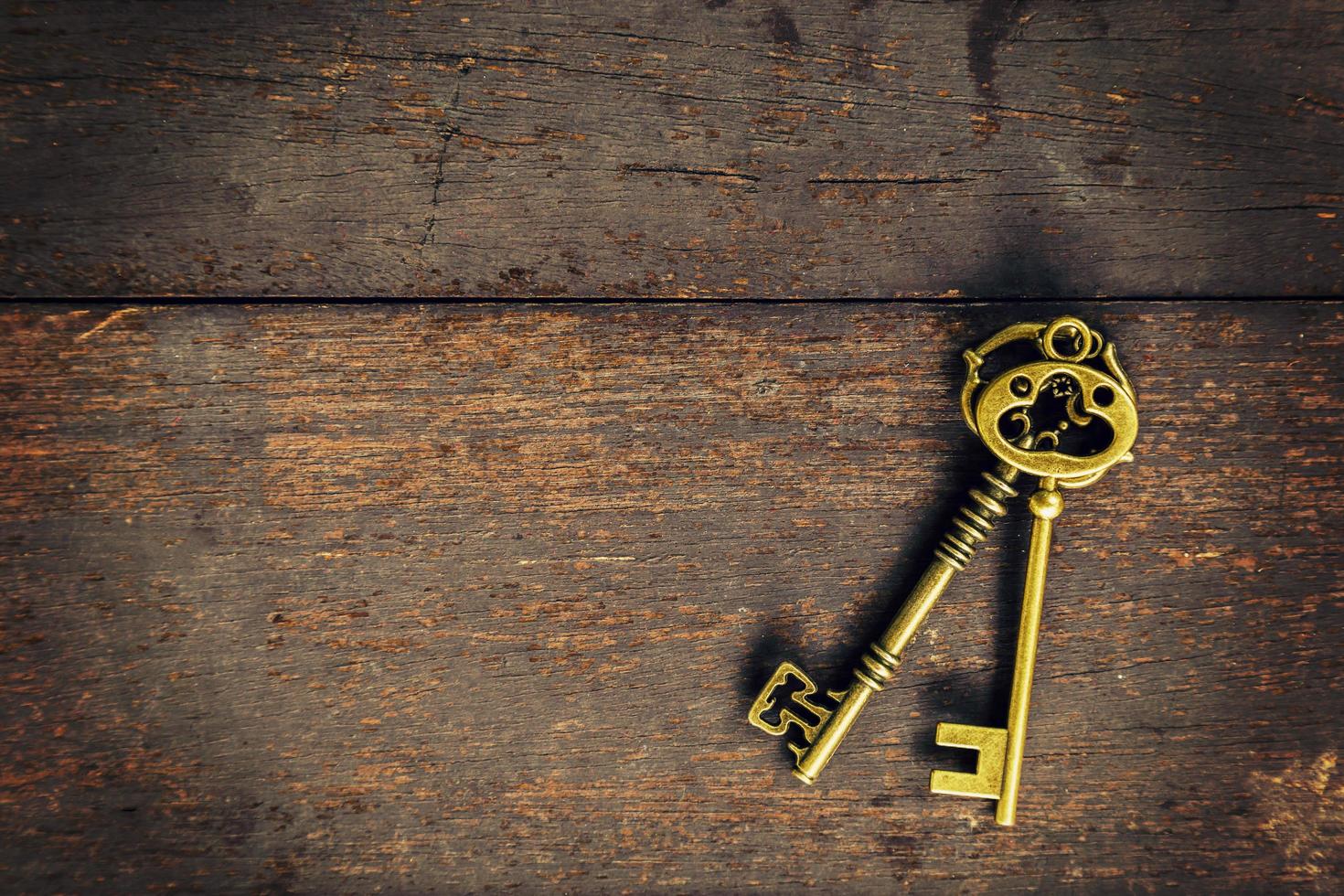 Old vintage key on wood texture background with space photo