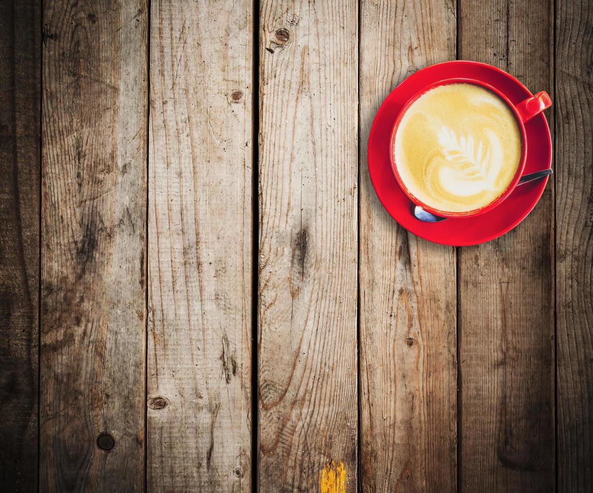 red cup and latte coffee on wood table with space photo