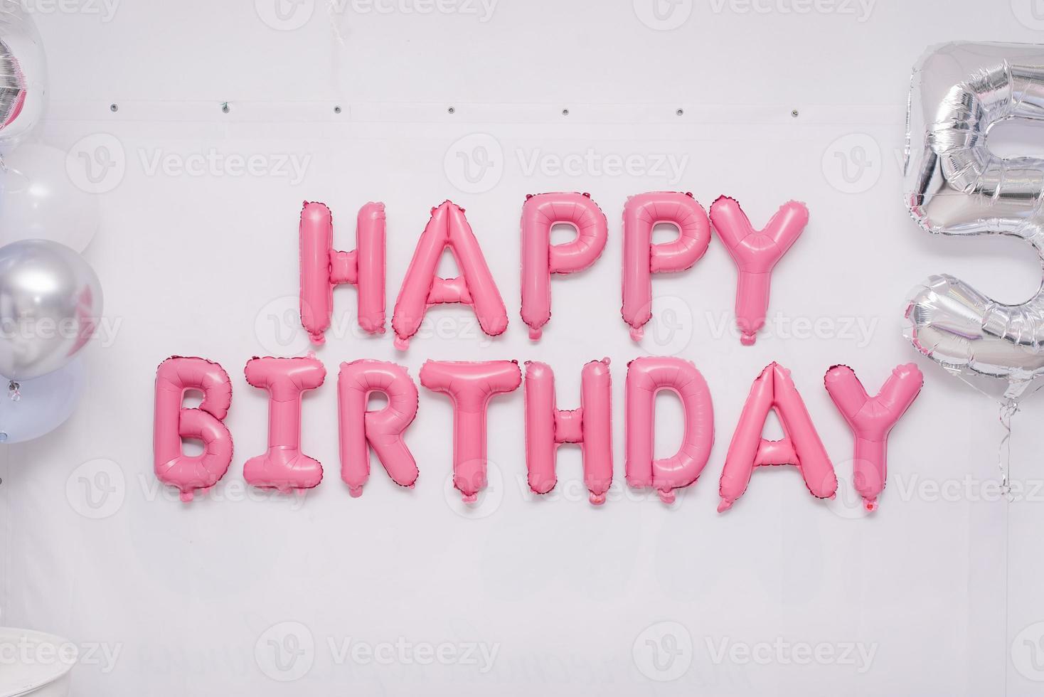 Pink garland of foil balloons happy birthday on holiday photo