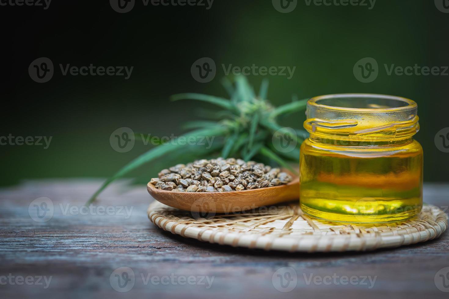 Glass bottles containing  hemp oil and hemp seeds in a wooden spoon,  drugs extracted CBD Cannabis Oil  of researchers or medical team. Herbal alternative medicine. photo