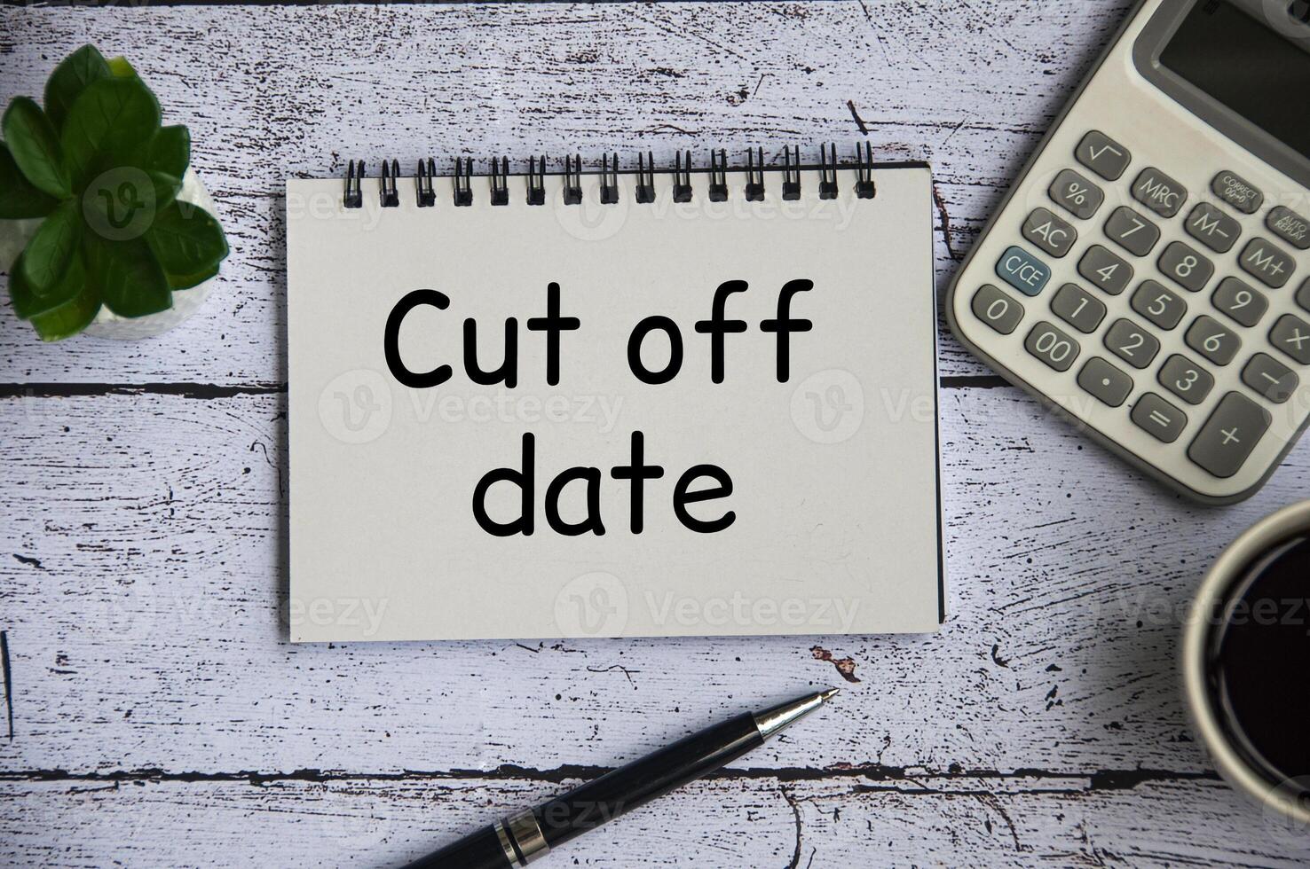 Cut off date text on notepad with table plant, calculator and pen