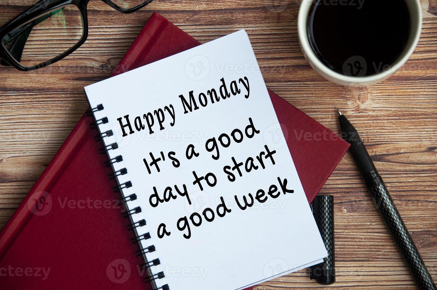 It is a good day to start a good week text on white notepad. With books, pen, coffee and glasses background photo