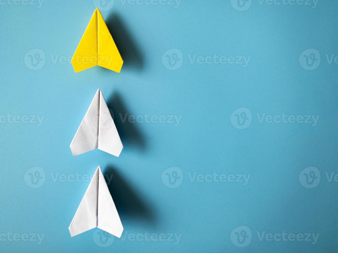 amarillo papel avión origami líder blanco aviones en azul antecedentes con personalizable espacio para texto. liderazgo habilidades concepto. foto