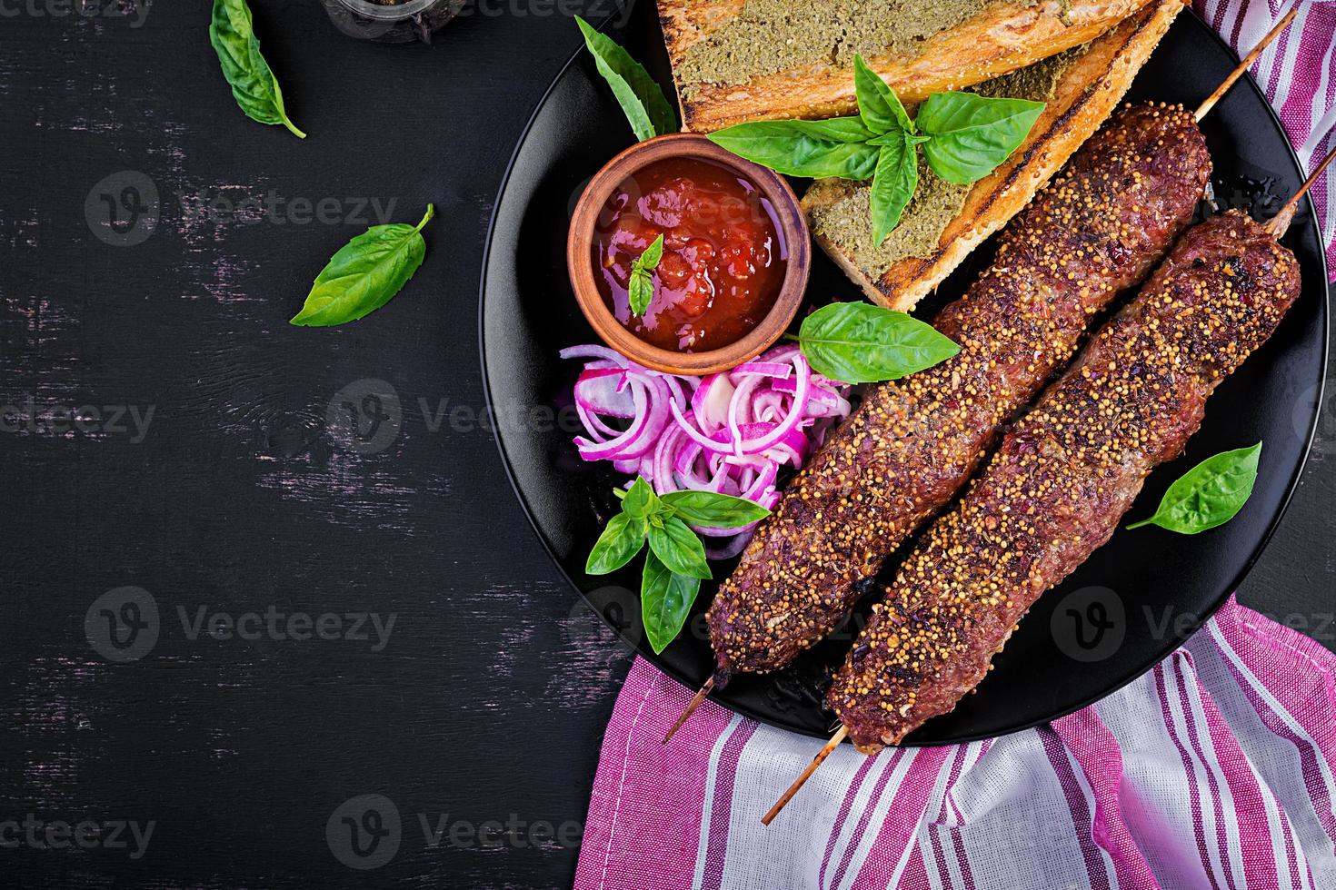 Kebab adana,  lamb and beef and toasts with pesto sauce. Top view photo