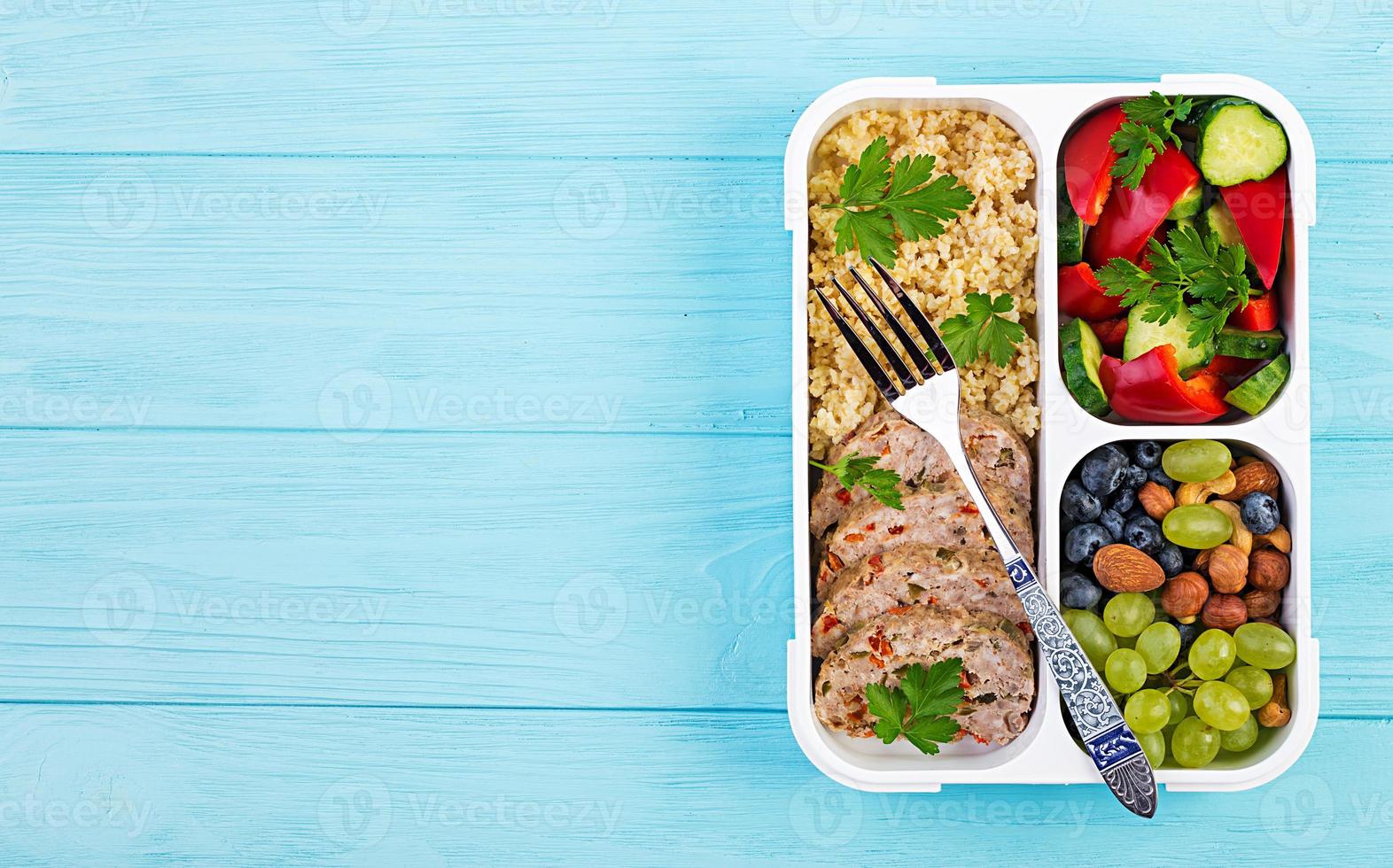 Lunch box  meatloaf, bulgur, nuts, cucumber  and berry. Healthy fitness food. Take away. Lunchbox. Top view photo