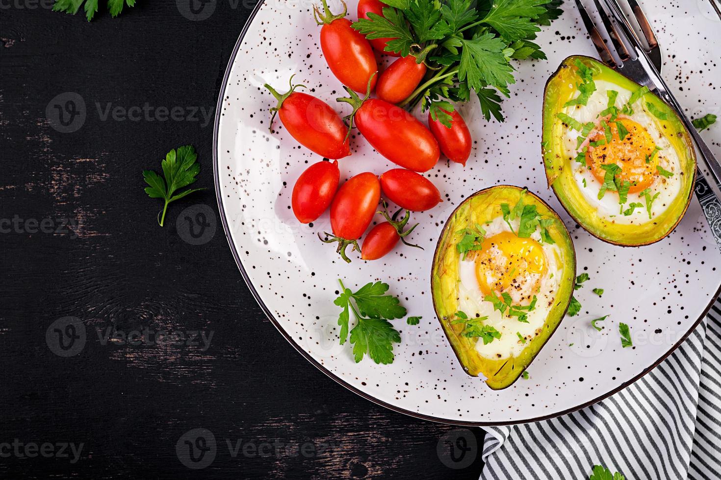 Avocado baked with egg and fresh salad. Vegetarian dish. Top view, overhead.  Ketogenic diet. Keto food photo