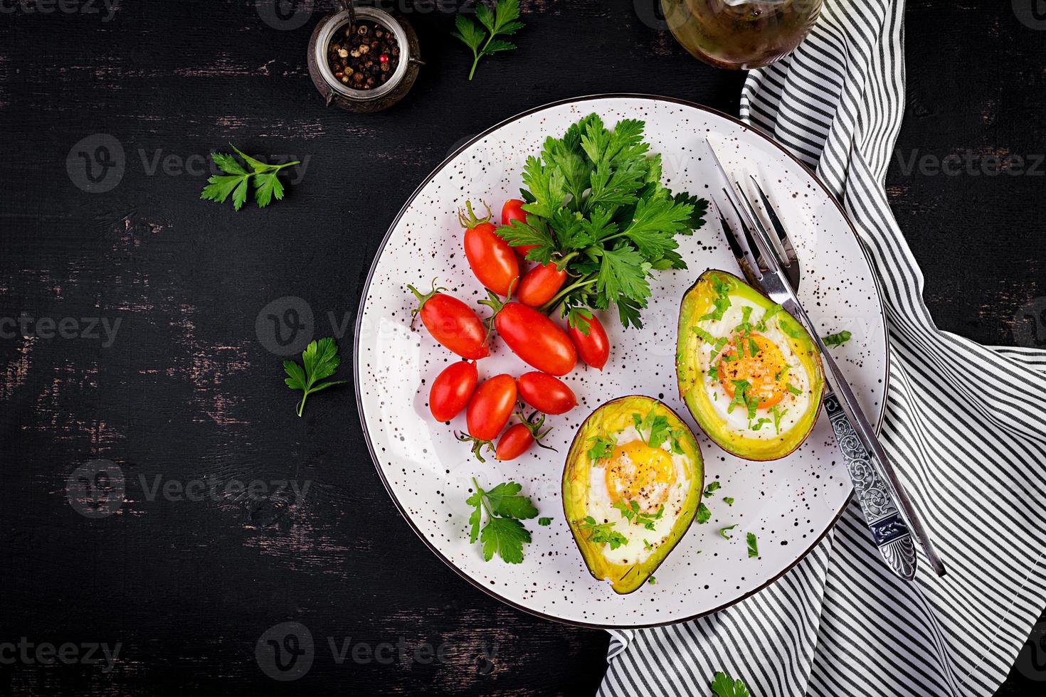Avocado baked with egg and fresh salad. Vegetarian dish. Top view, overhead.  Ketogenic diet. Keto food photo