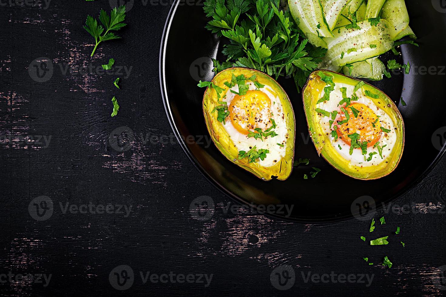 Avocado baked with egg and fresh salad. Vegetarian dish. Top view, overhead.  Ketogenic diet. Keto food photo