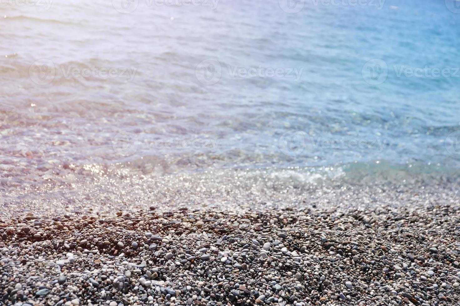 banco de guijarros con el mar y la playa al fondo foto