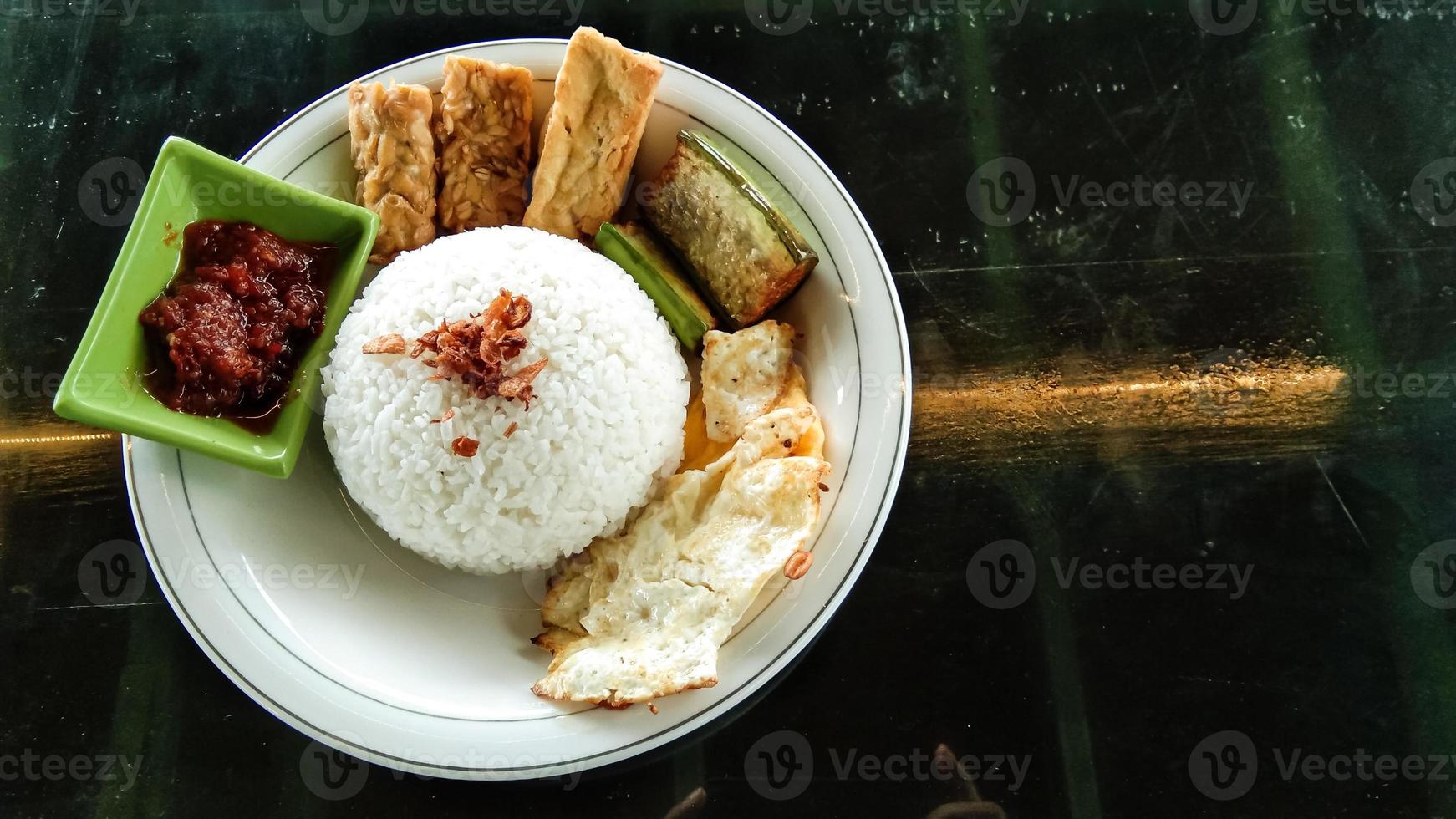 traditional menu called T4 which consists of rice, tofu, tempeh, eggs sunny side up, and eggplant photo