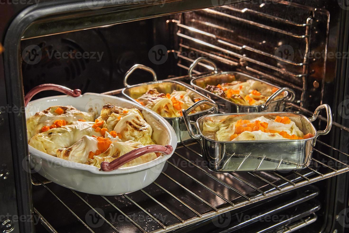 repollo rollos con salmón, zanahorias y salsa son horneado en el horno. francés receta foto