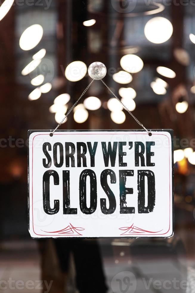 Inscription on metal plate sorry we are closed sign on glass door business office, store or restaurant coronavirus pandemic commerce crisis concept. Closure, suspension, or bankruptcy photo