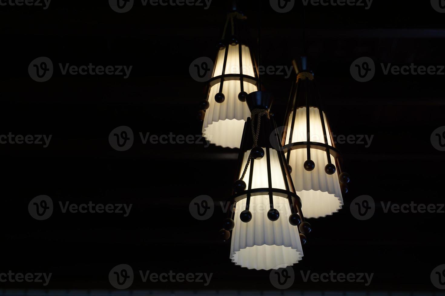 3 white pendant lamps on a black background to stand out and the beauty of the light. Soft and selective focus. photo