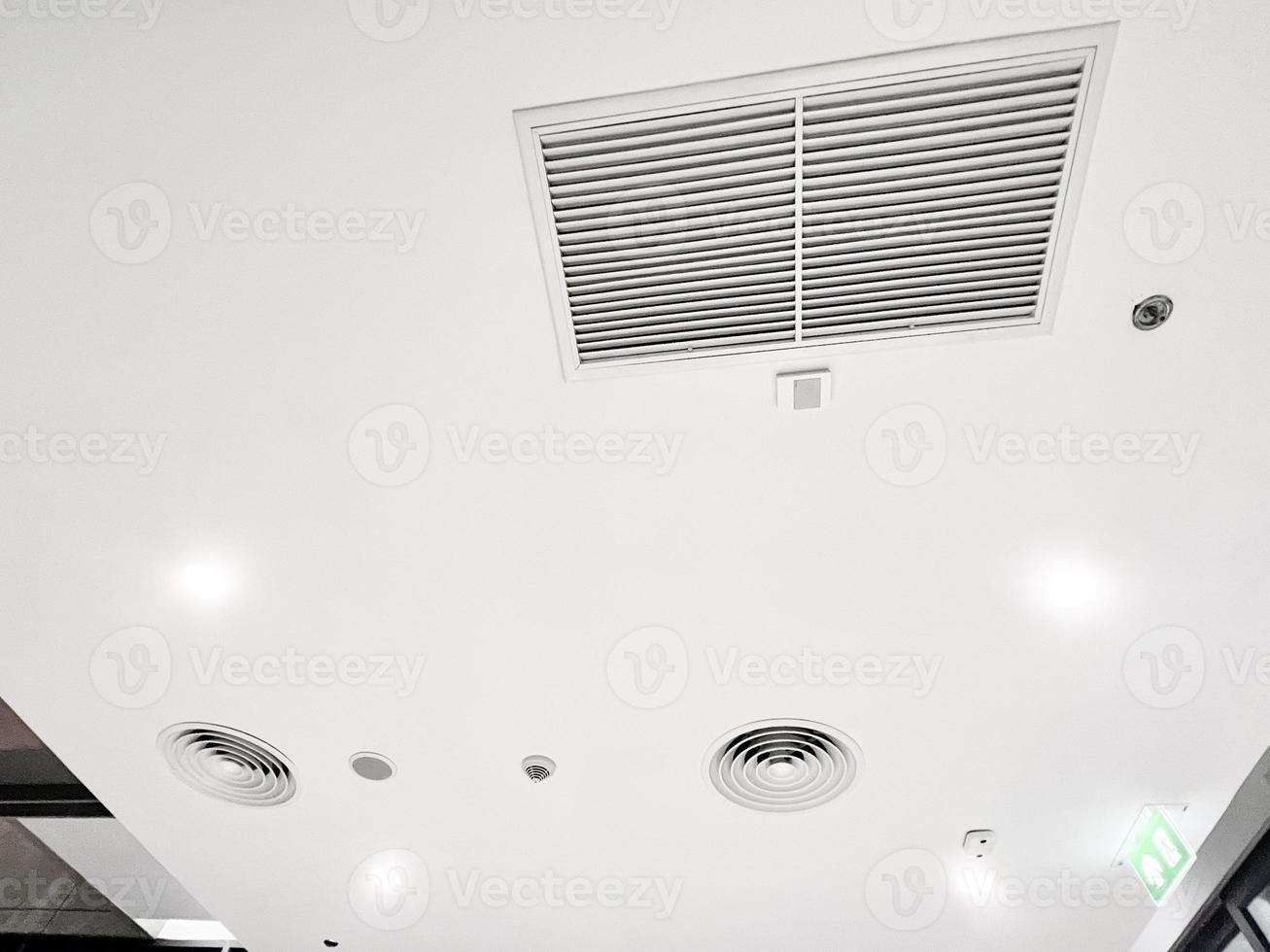 Ceiling mounted cassette type air conditioner and modern lamp light on white ceiling. duct air conditioner for home or office photo