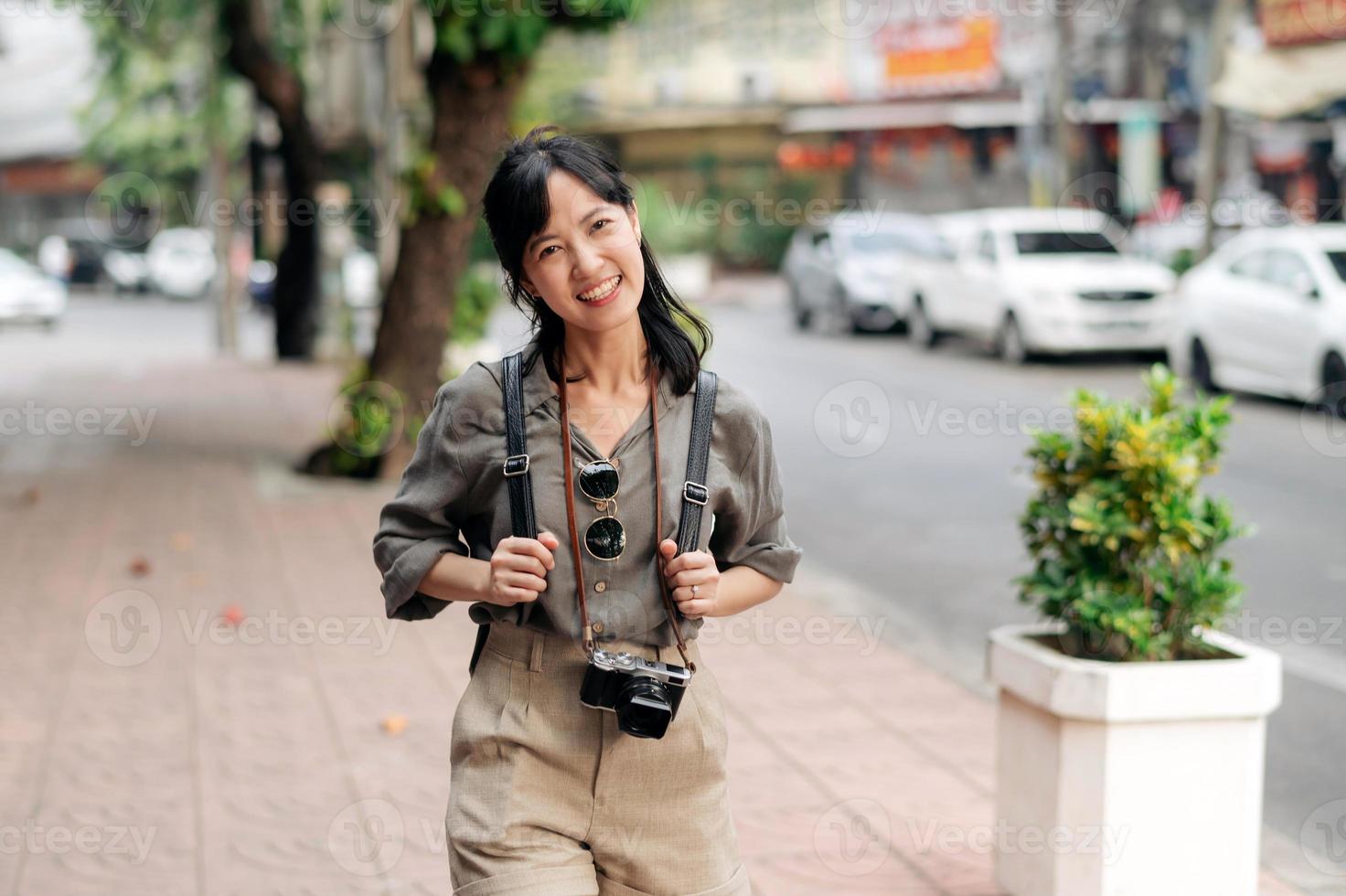 joven asiático mujer mochila viajero disfrutando calle cultural local sitio y sonrisa. foto