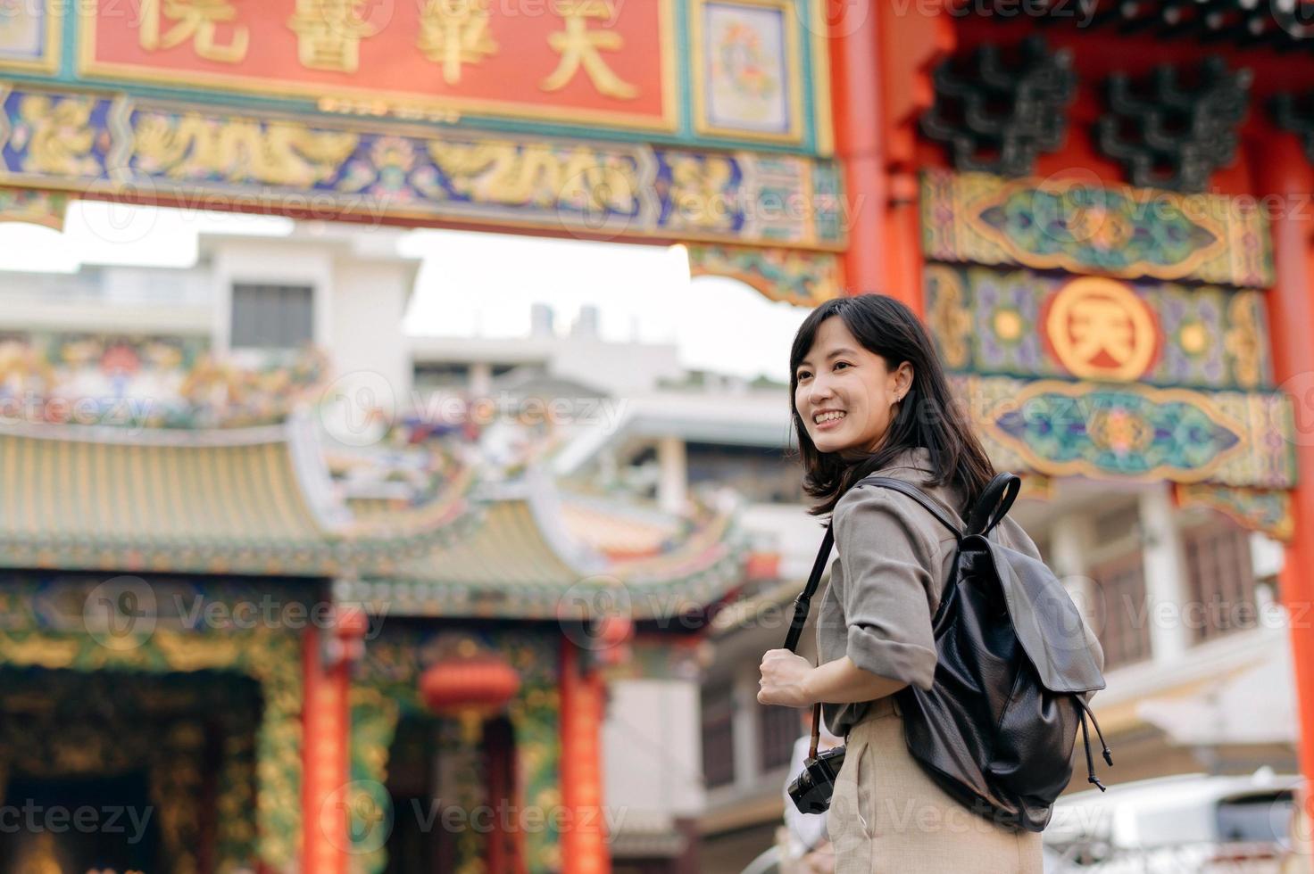 Young Asian woman backpack traveler enjoying China town street food market in Bangkok, Thailand. Traveler checking out side streets. photo