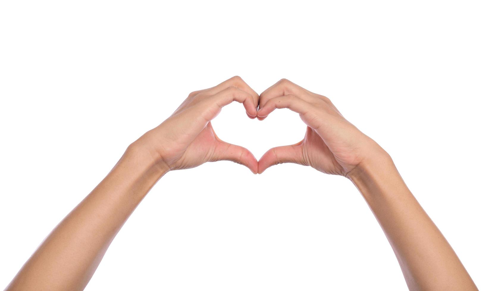 manos de mujer haciendo una forma de corazón sobre un fondo blanco aislado foto