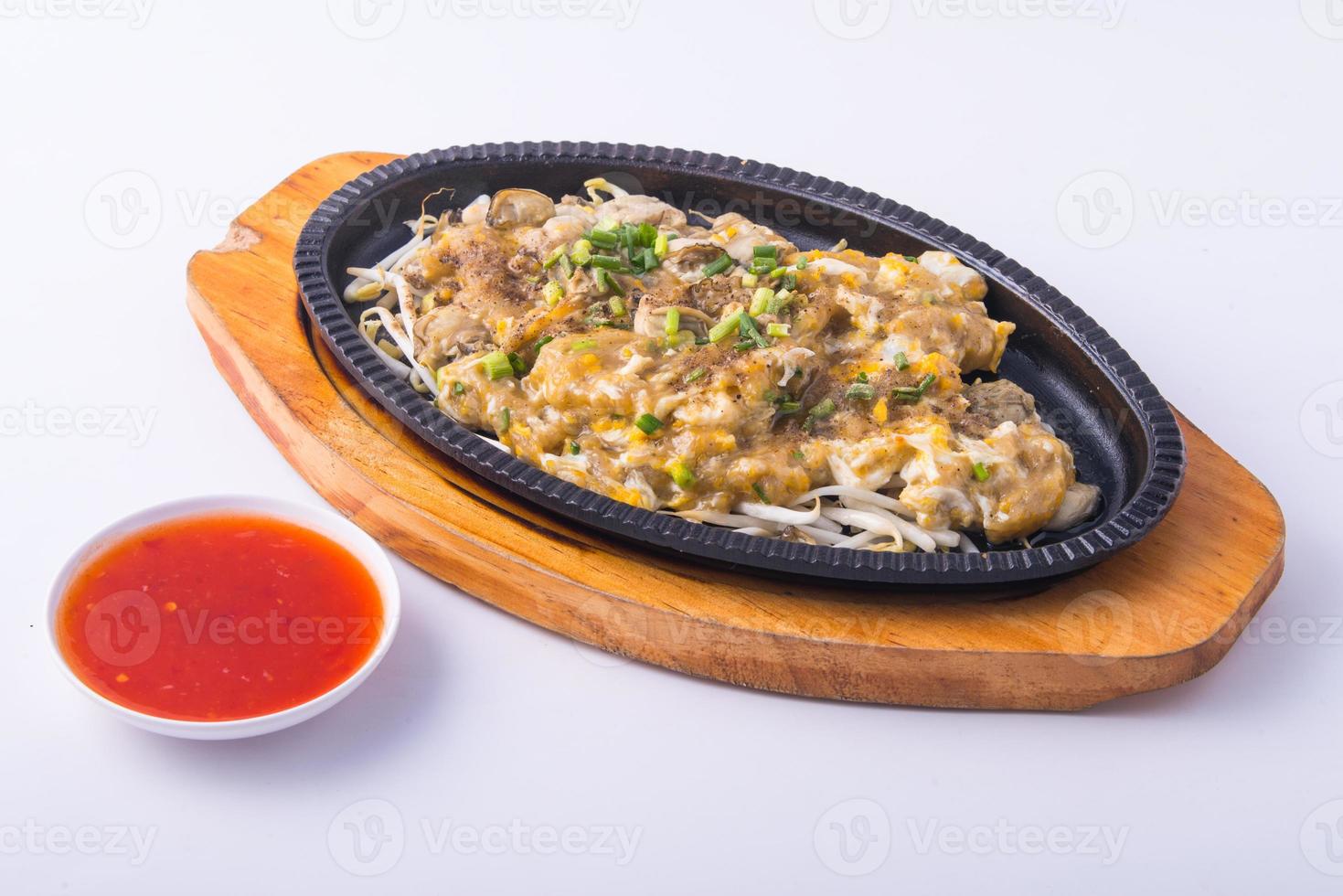 Crispy fried mussel pancake with chili sauce on the wooden plate . photo