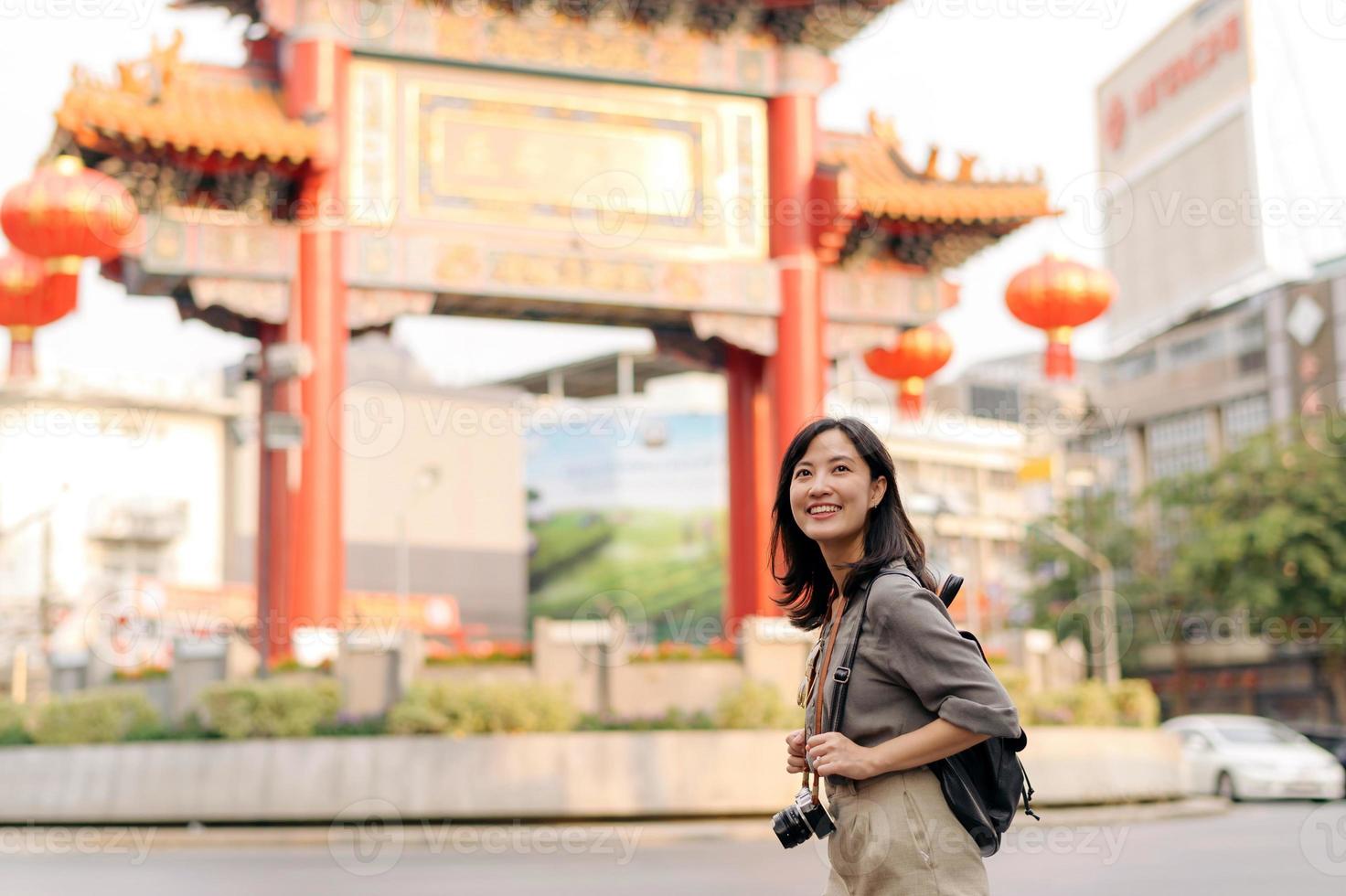 Young Asian woman backpack traveler enjoying China town street food market in Bangkok, Thailand. Traveler checking out side streets. photo