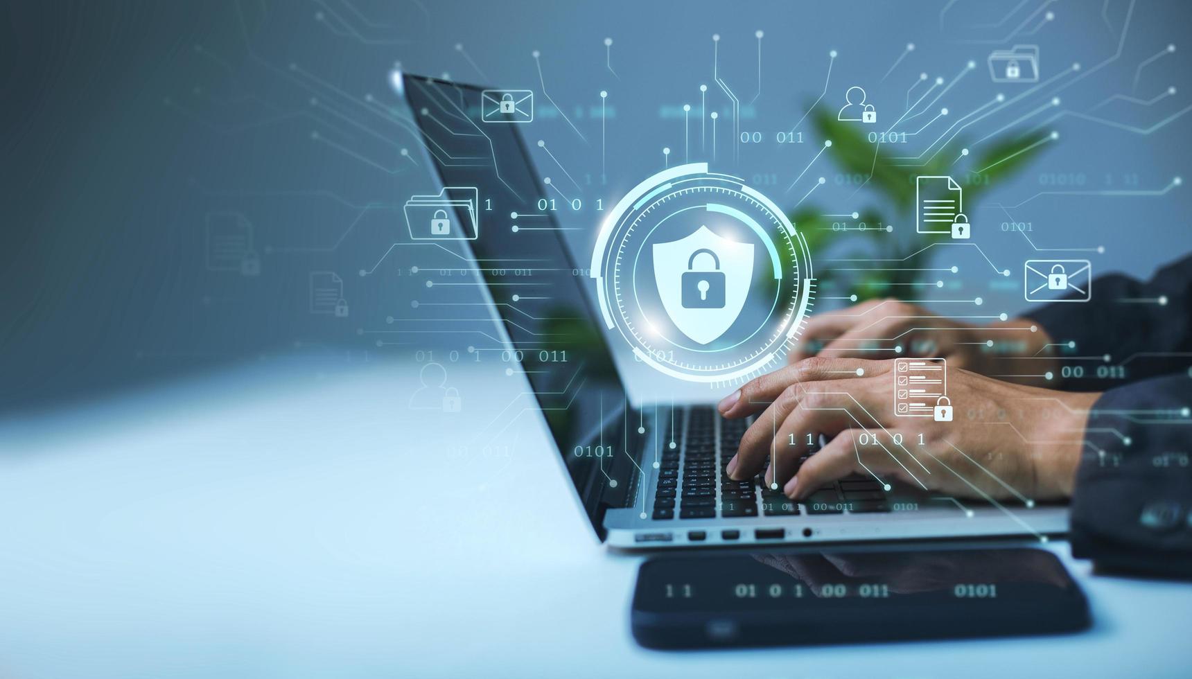 A businessman works on his laptop at home with a virtual display showing a symbol to signify cyber security privacy and online data protection photo