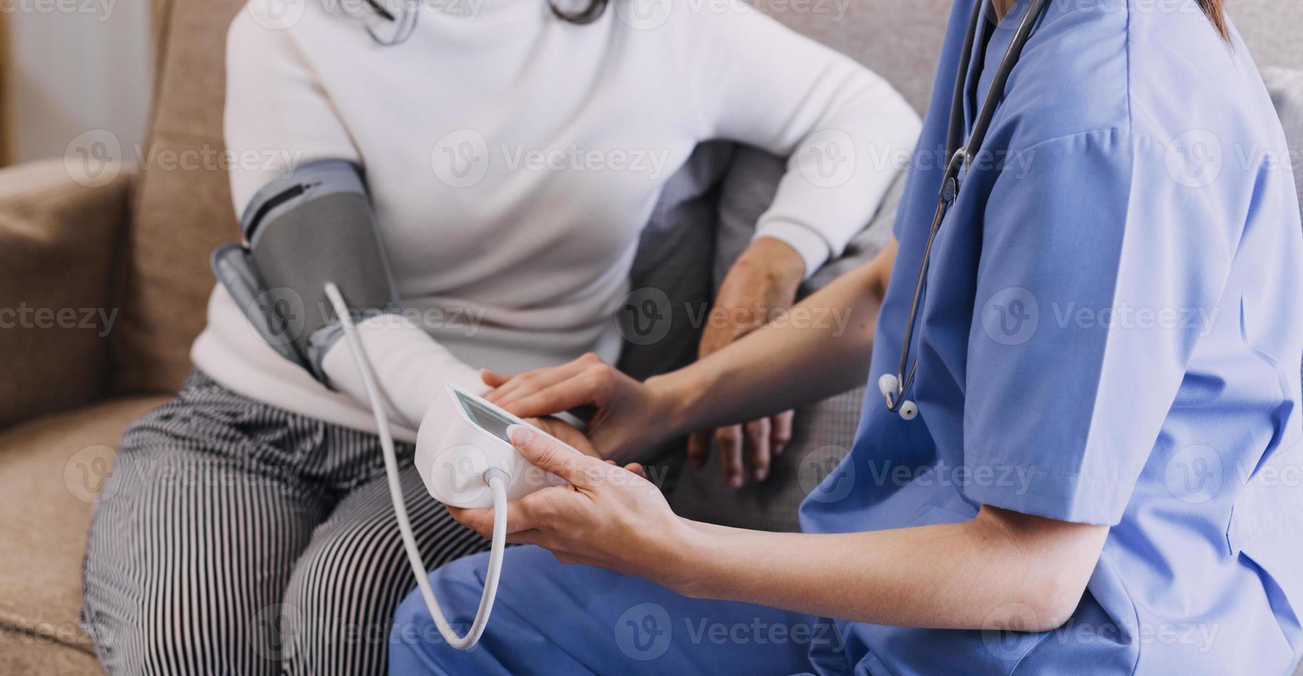 Homecare nursing service and elderly people cardiology healthcare. Close up of young hispanic female doctor nurse check mature caucasian man patient heartbeat using stethoscope during visit photo