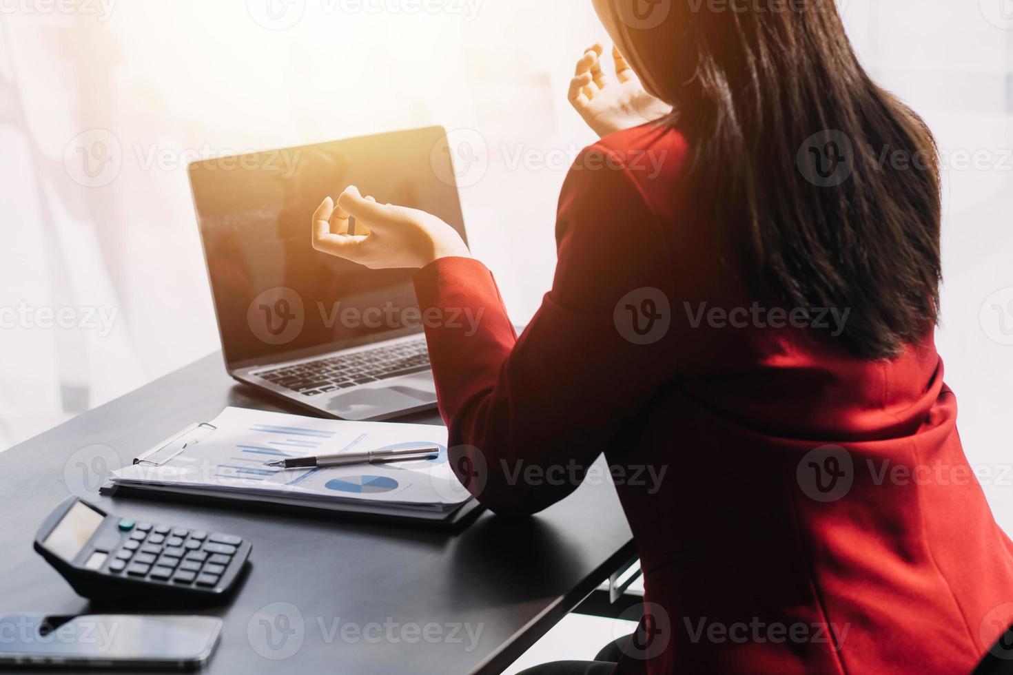 Asian Business woman using calculator and laptop for doing math finance on an office desk, tax, report, accounting, statistics, and analytical research concept photo