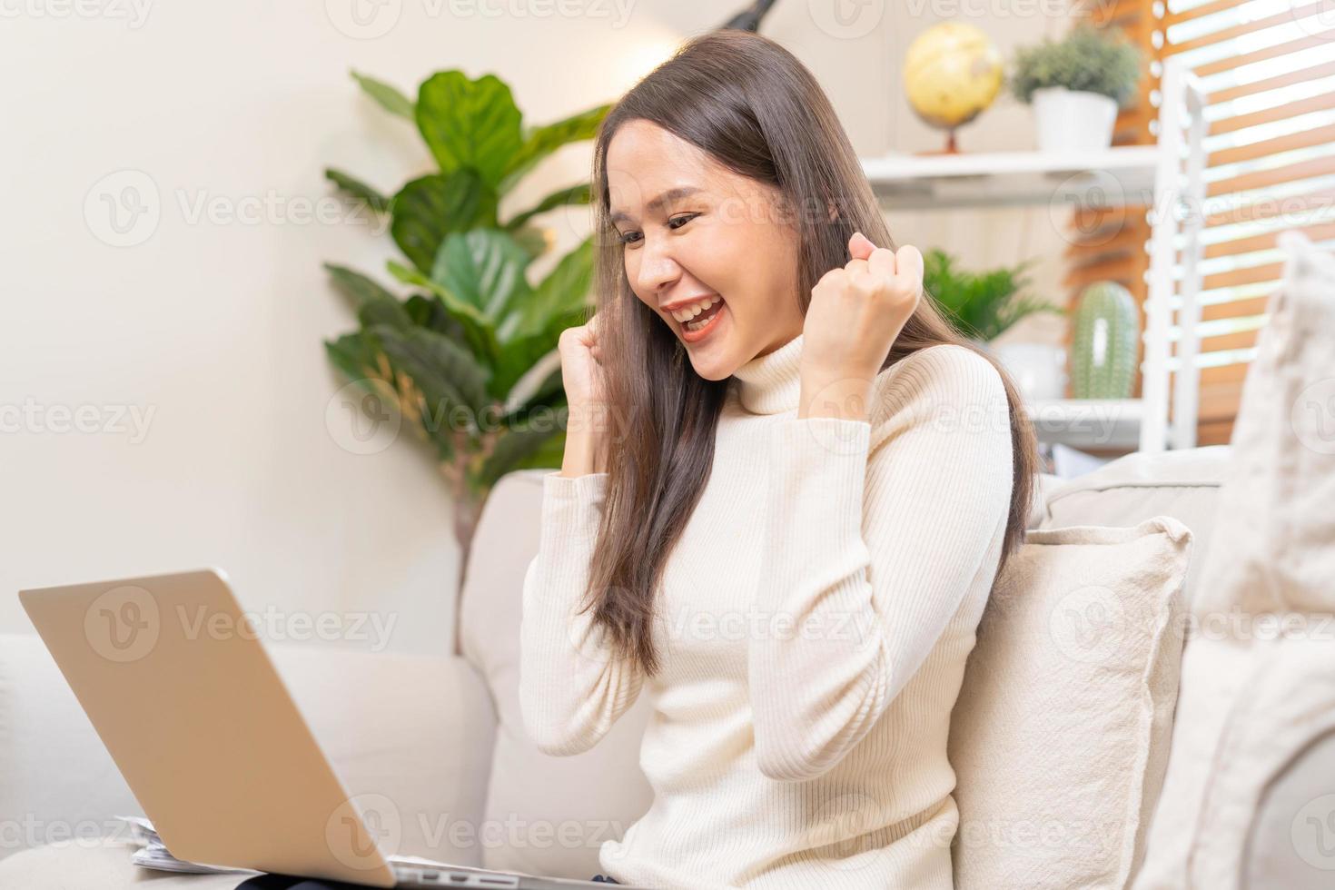 contento alegre, satisfecho asiático joven persona de libre dedicación mujer, niña sentado en sofá o sofá, utilizando ordenador portátil computadora en vivo habitación a hogar, mirando y sonriente a pantalla, empresario disfrutando con trabajar, wfh foto