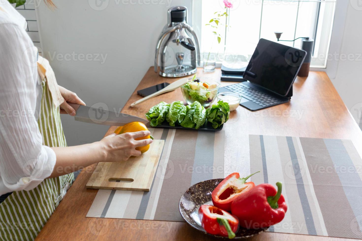 A young woman prepares bell peppers for her breakfast and is ready for a healthy meal on the table with healthy, organic vegetables on the table. healthy food preparation ideas photo