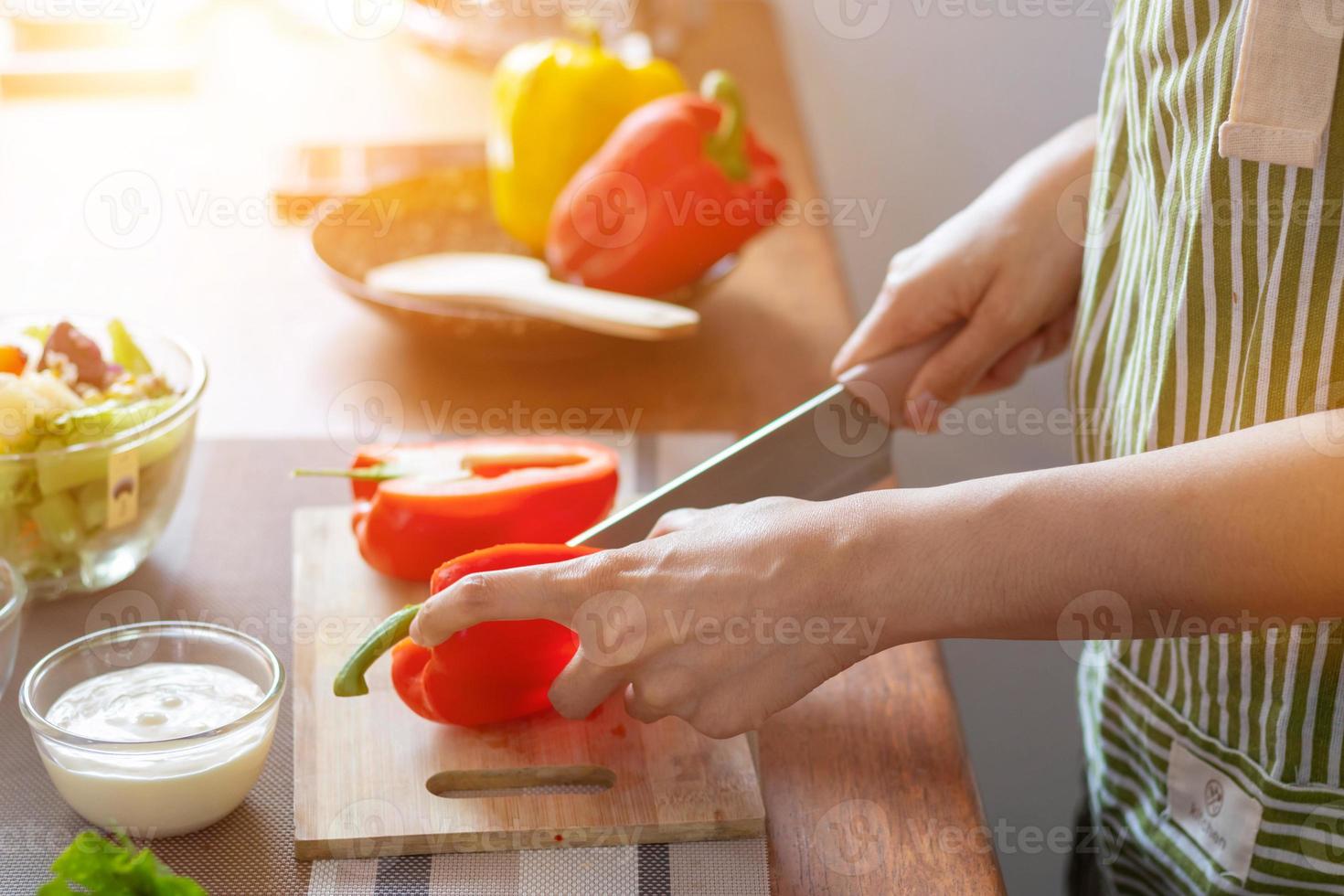 un joven mujer prepara campana pimientos para su desayuno y es Listo para un sano comida en el mesa con saludable, orgánico vegetales en el mesa. sano comida preparación ideas foto