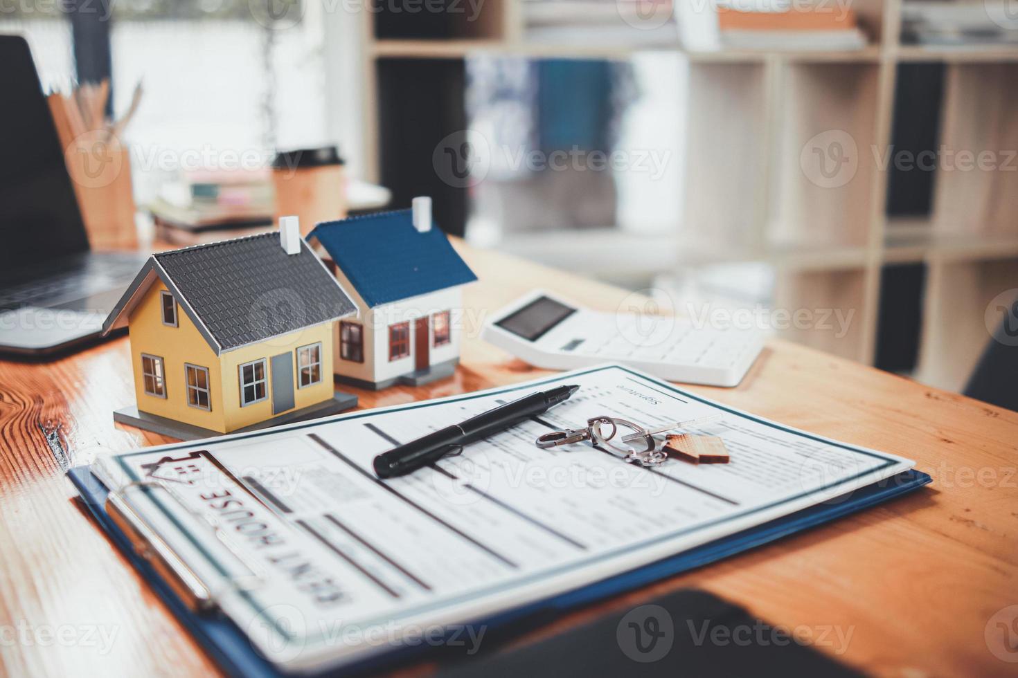 Real estate sales documents and model homes are placed on tables inside real estate sales offices to prepare prospective buyers to sign real estate sales contracts with dealers. photo