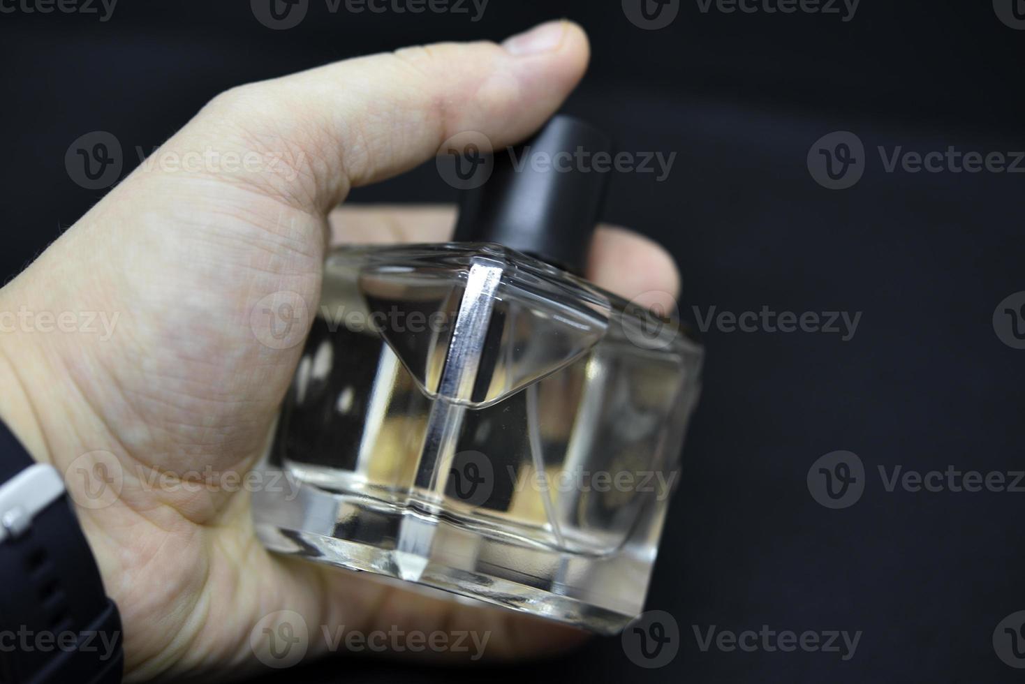 A glass perfume bottle on a black background. A bottle of perfume in close-up. Perfumery. photo