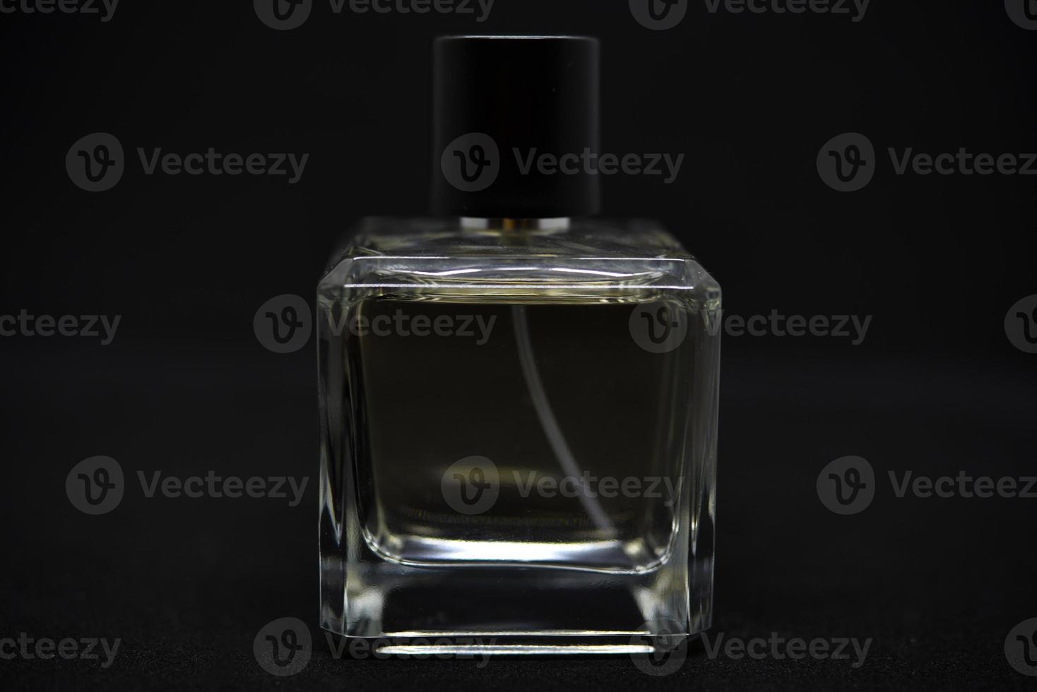A glass perfume bottle on a black background. A bottle of perfume in close-up. Perfumery. photo
