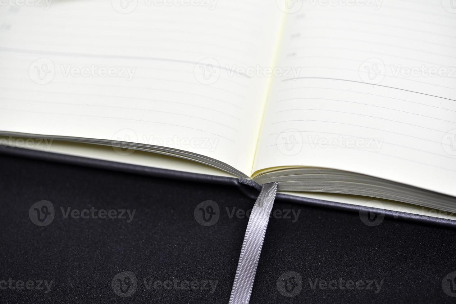 An open book on a black background. An open notebook. Blank pages of the notebook. photo