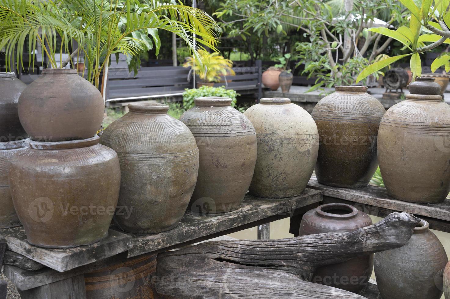 Several ancient terracotta jars with wooden lids on top. photo