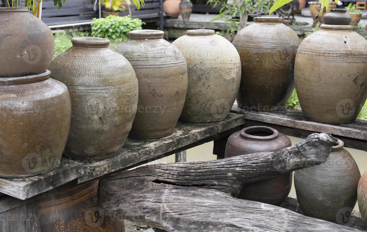 Several ancient terracotta jars with wooden lids on top. photo