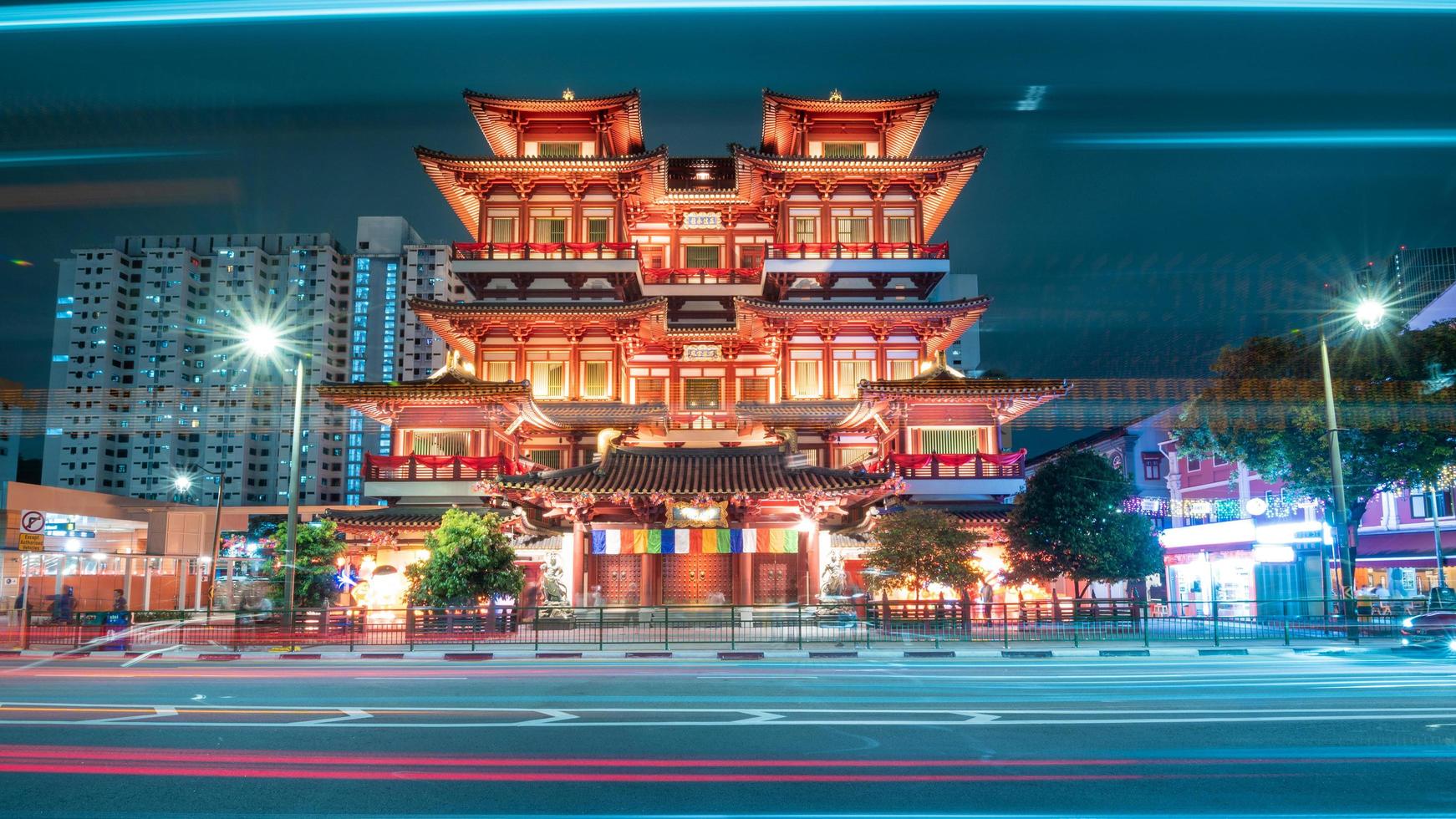 chinatown singapore 27 12 2022 the buddha tooth relic temple at night in the chinatown district of singapore with long exposure of traffic lights free photo