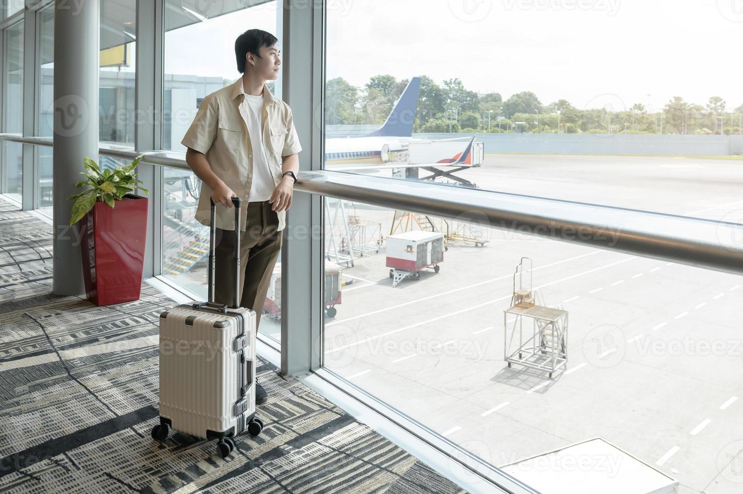 A young asian man  with suitcase , check in at International airport , vacation travel and transportation concept photo