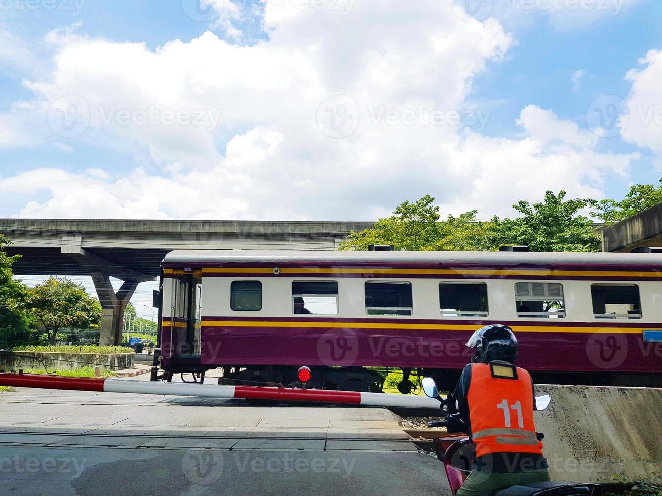 Motorcycle taxis wear safety helmet waiting for the train to go first with green tree, highway and sky background. Transportation public and vehicle concept. photo