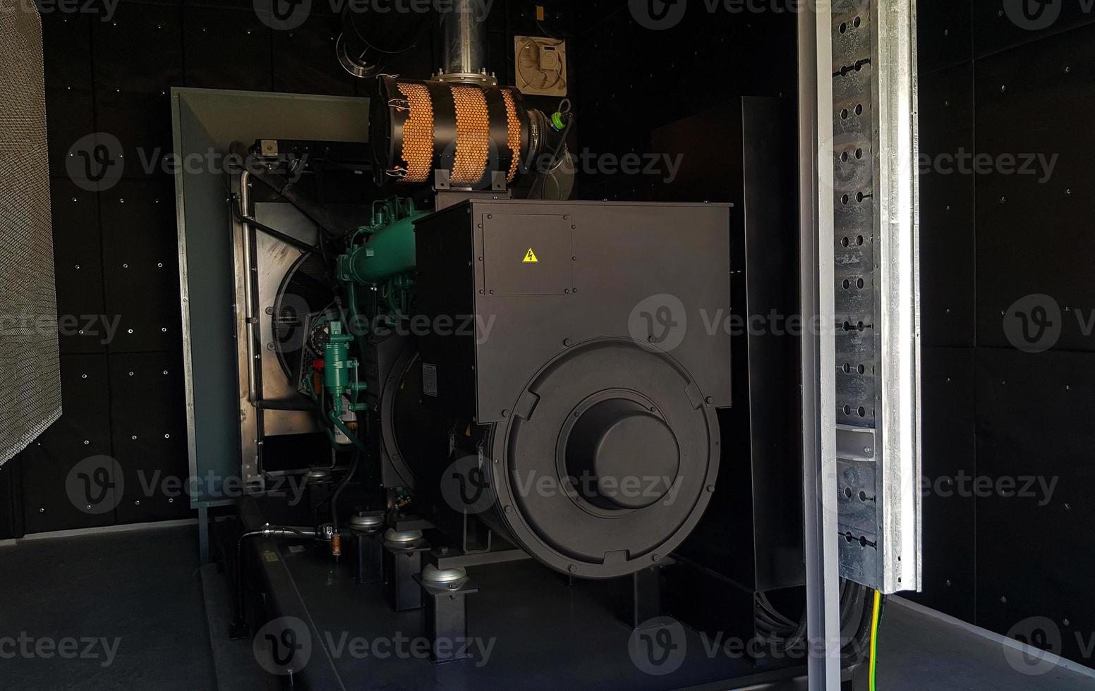 Black steel generator in electrical system room for backup electricity, lighting and facility of building or office when power failure, outage or down. Machine for distributing electricity to devices. photo