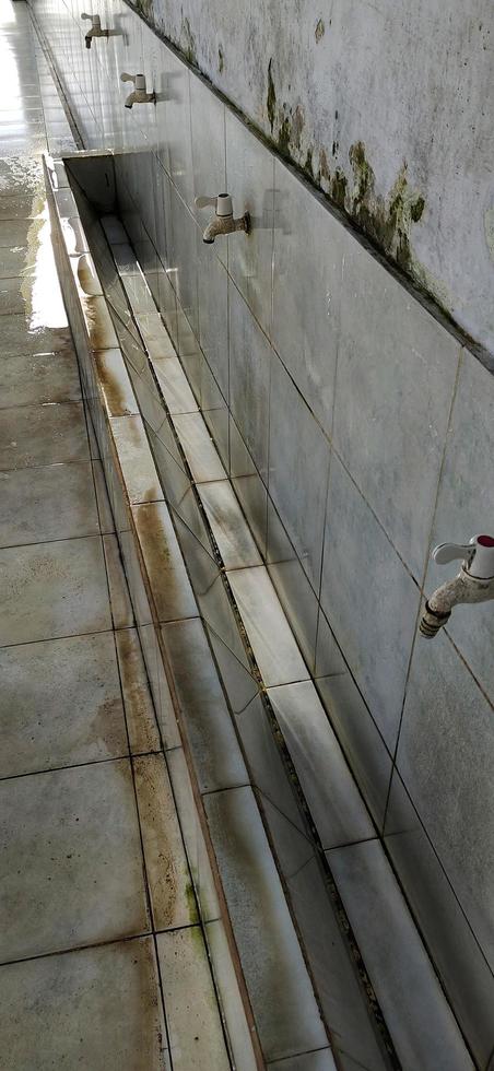 Portrait of a row of white water faucets at the mosque's ablution area photo